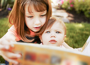 Mädchen und Kleinkind mit Buch